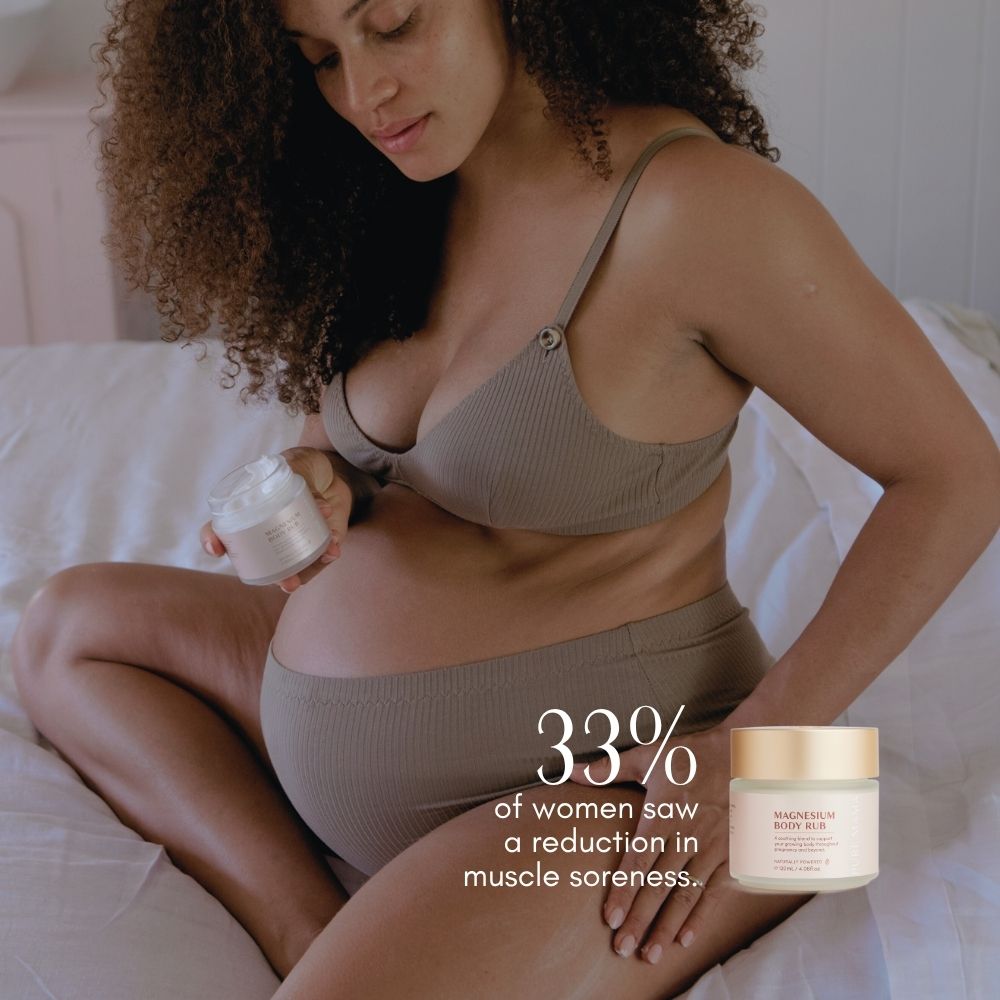 A pregnant woman in beige Pure Mama underwear sits on a bed, applying Pure Mama Magnesium Body Rub to her belly. Text reads, 33% of women saw reduced aches and pains. A jar labeled Magnesium Body Rub is shown.