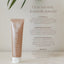 A tube of Pure Mama NZ Nipple Butter stands upright on a neutral background, with text highlighting its natural ingredients and cracked skin repair benefits in a light, minimalist setting.