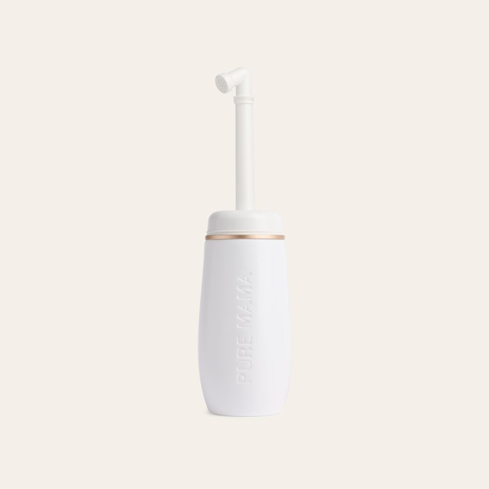 A white plastic Pure Mama NZ Peri Wash Bottle with a curved nozzle, ergonomic design, and PURE MAMA embossed on the side stands upright on a light background—ideal for gentle postpartum cleansing.