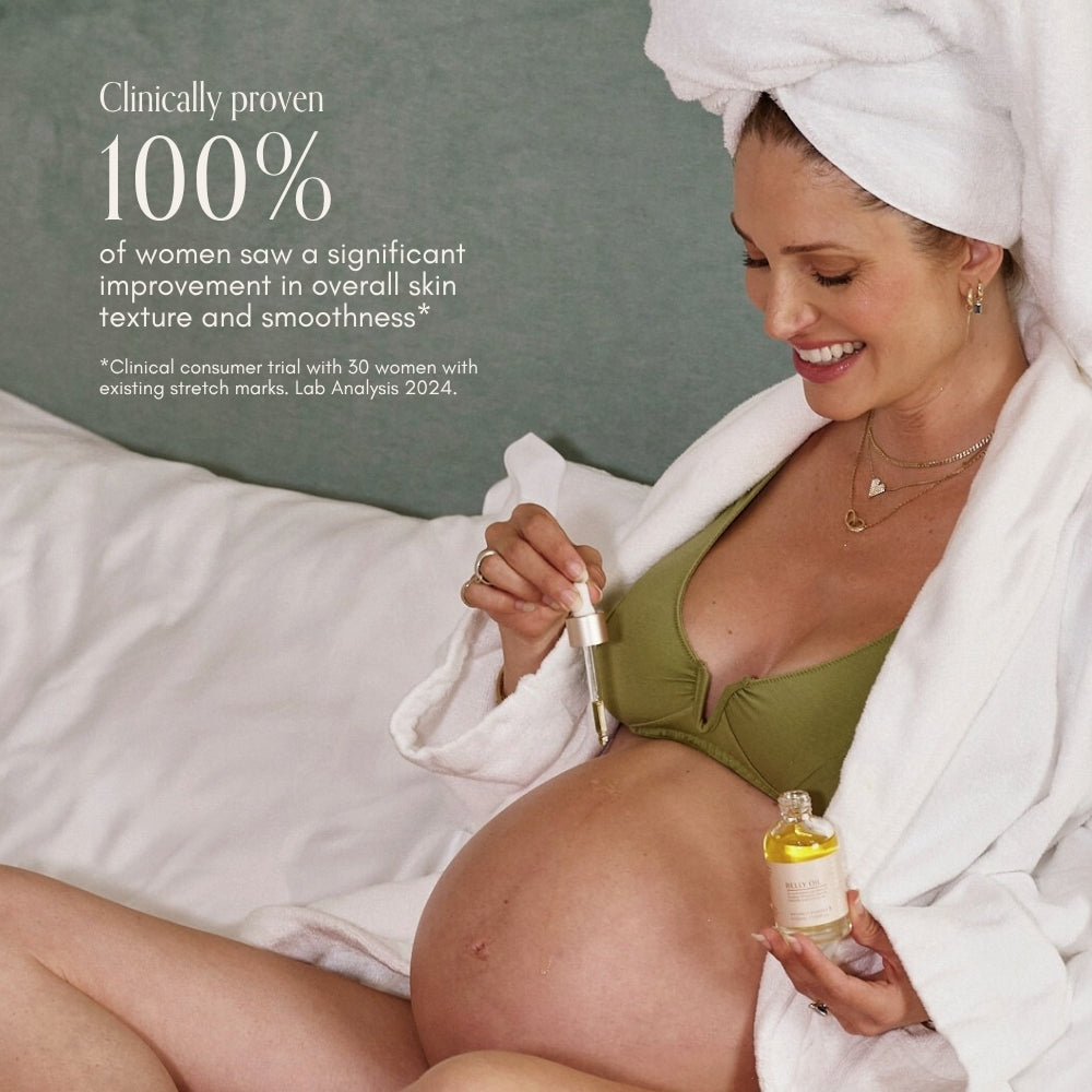 A smiling pregnant woman in a bikini top and white robe applies Pure Mama NZs Belly Spa Kit oil to her belly, using a dropper. Text highlights clinical results for improved skin texture and smoothness.