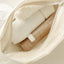 A close-up of an open beige zipper pouch shows two Pure Mama NZ Peri Wash Bottles for postpartum care, featuring ergonomic, nude-colored packaging arranged neatly inside the textured pouch.